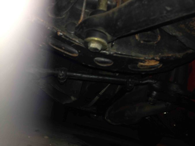 Here's the general area under the passenger side lower control arm. Notice the lower control arm is braced with a piece of sheet metal from FirmFeel. This stiffener plate is recommended for heavy duty front sway bars to reduce the stock lower control arms from twisting into mush with hot cornering.